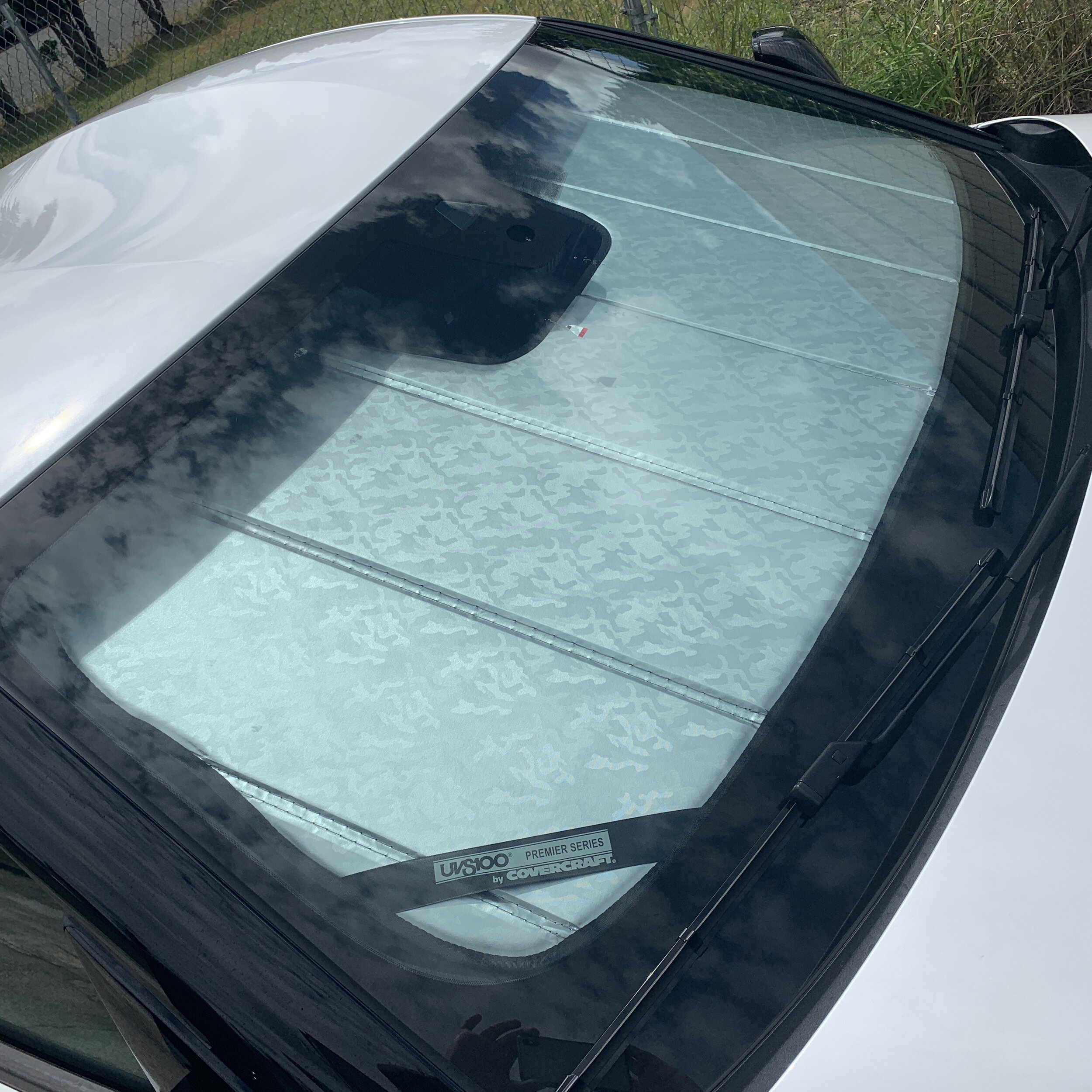 Fitted windshield sun screen photographed against a car outdoors in daylight