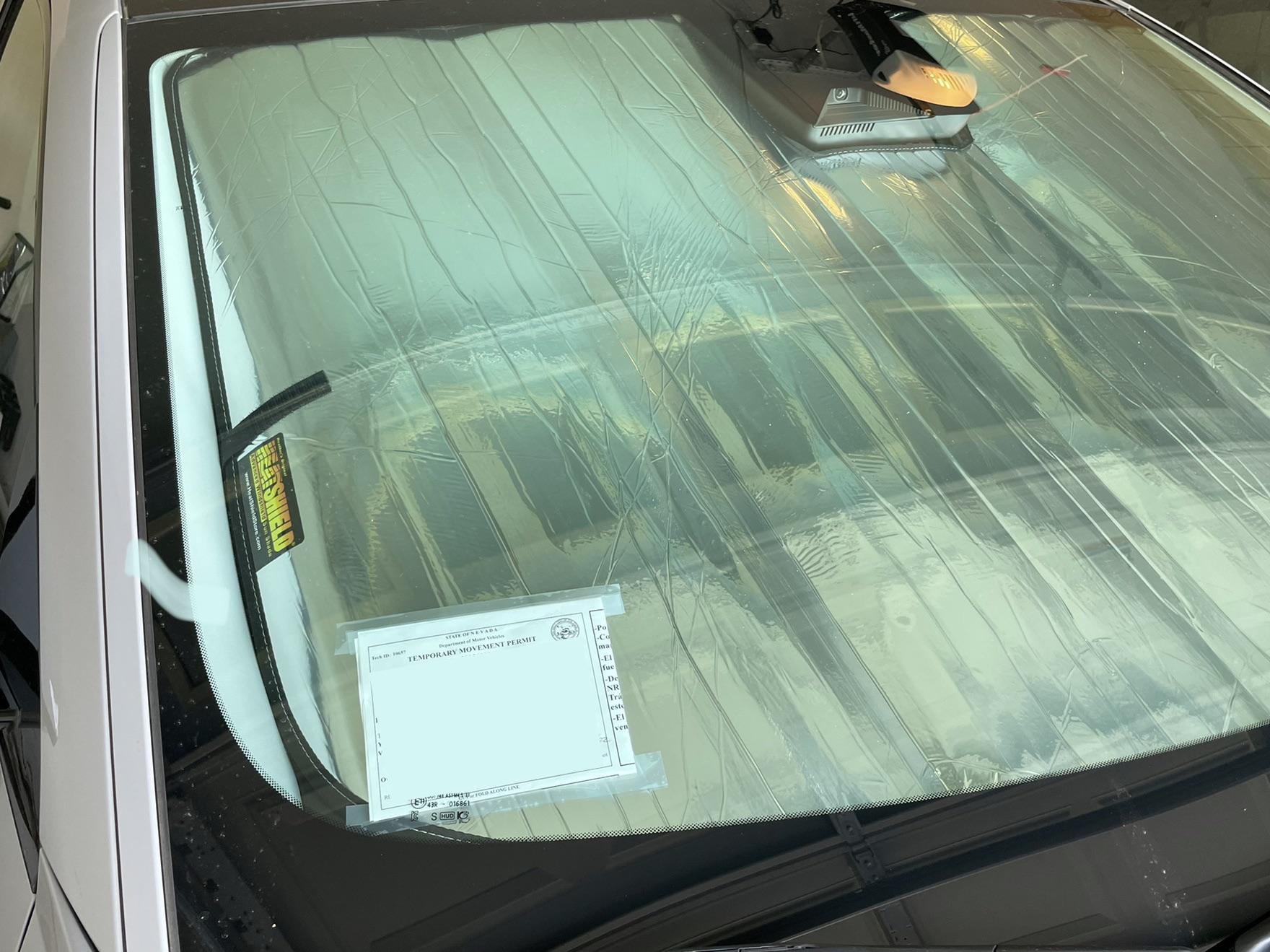 Reflective laminate sun shade seen through the windshield from the front of the car